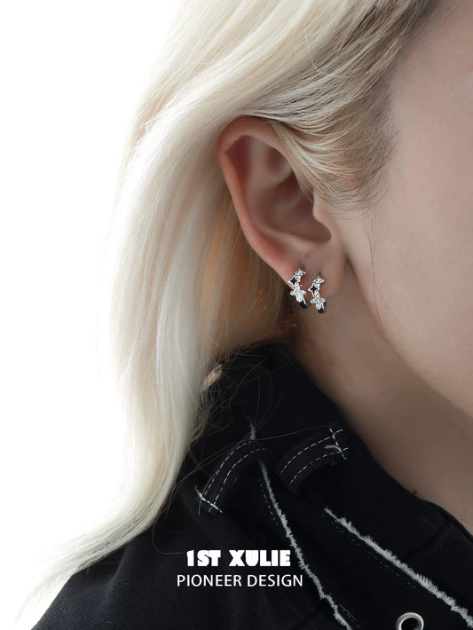 Y2K starpunk thorn earrings in silver design showcased on a model's ear with blonde hair