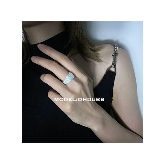 Stylish silver bandage ring worn on a model's hand showcasing its elegant design