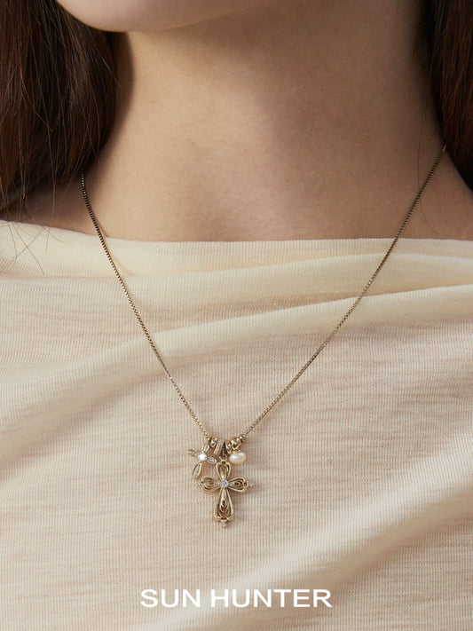 SUN HUNTER faith charm necklace featuring a delicate cross design on a gold chain