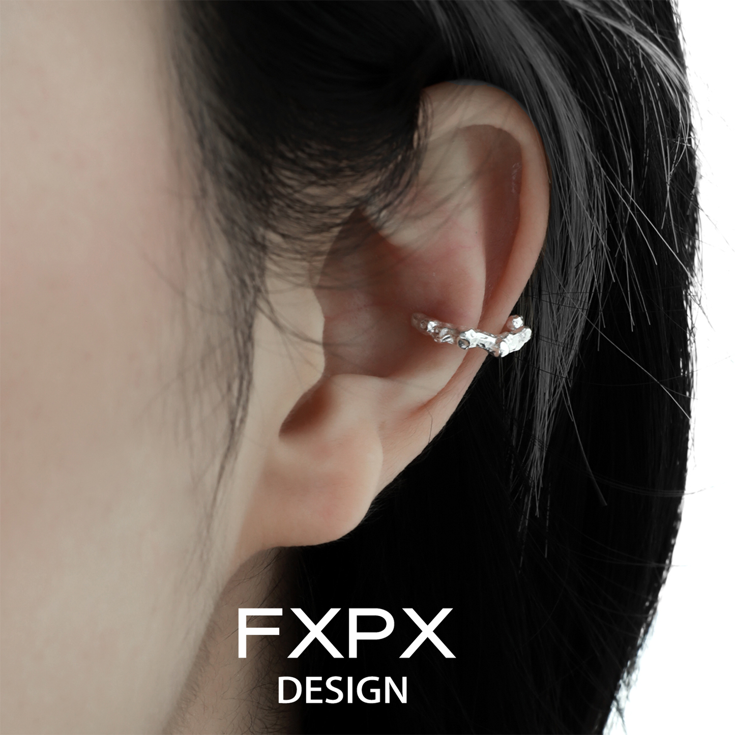 Irregular silver earrings showcased on the ear, highlighting unique design by FXPX