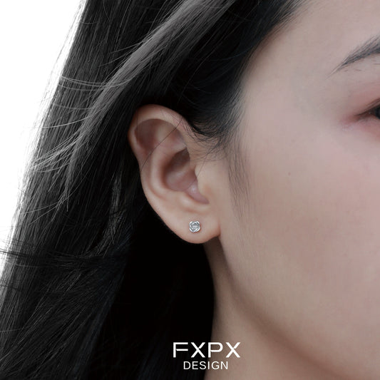 Minimal rose silver earrings showcased on a model's ear with flowing hair