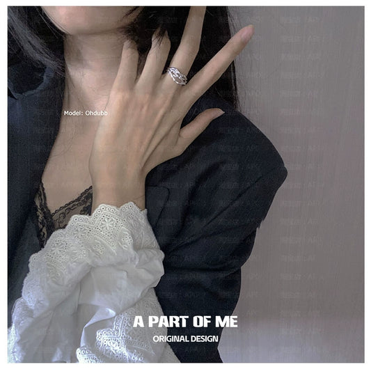 Irregular silver ring showcased on a model's hand, styled with elegant attire for a chic look