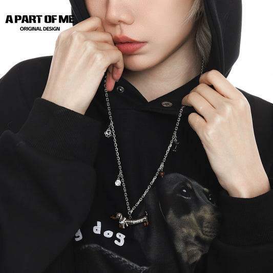 Lucky dachshund necklace displayed on a model wearing a black hoodie, showcasing its charm and design