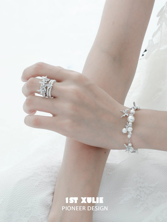 Elegant pearl butterfly ring alongside matching pearl bracelet, ideal for special occasions