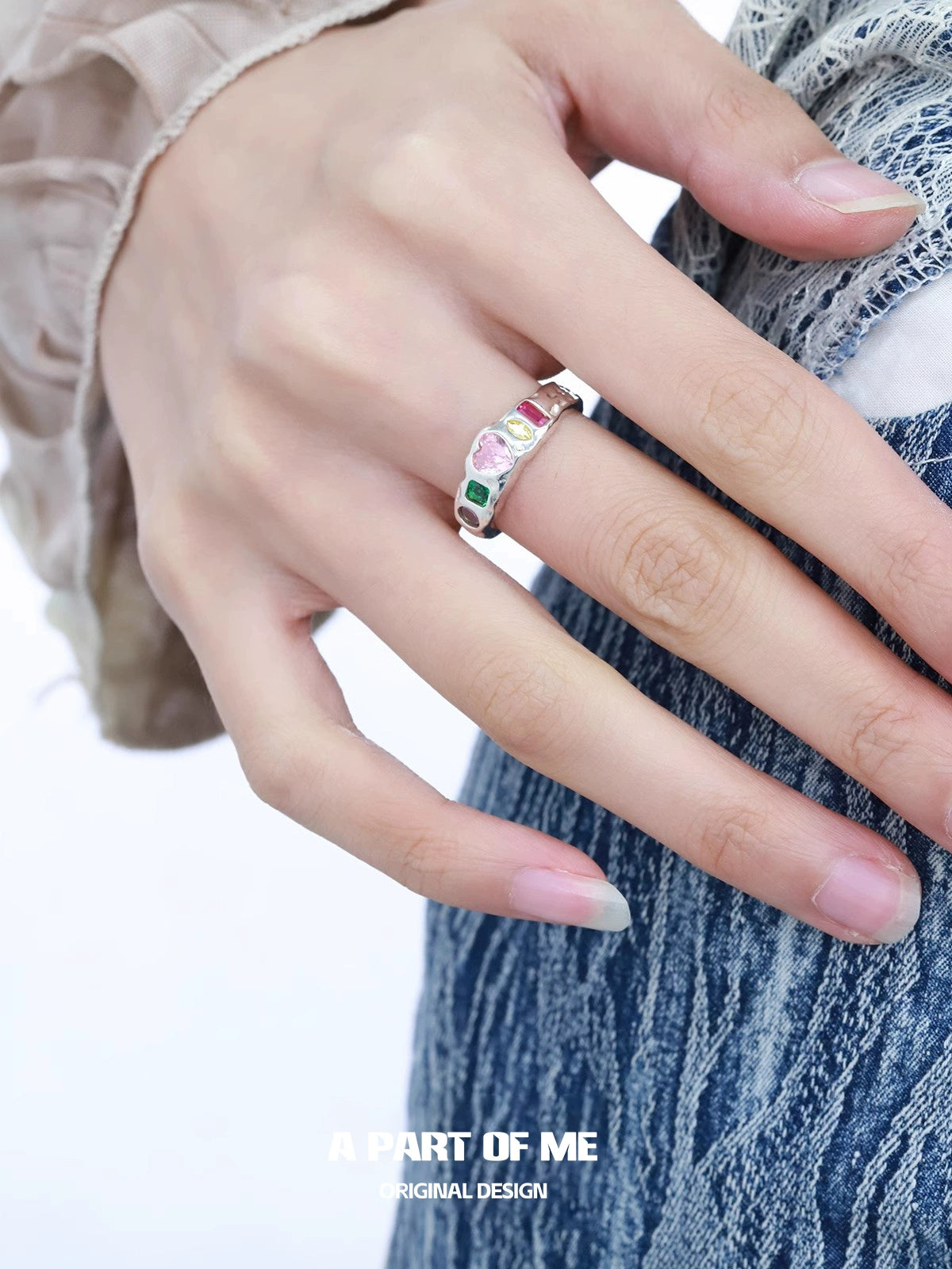 A stylish rainbow zircon love ring featured on a hand with long nails, perfect for romantic occasions