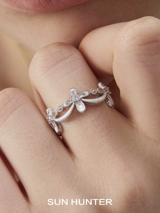 Elegant SUN HUNTER shimmer cross ring with delicate floral design and sparkling accents