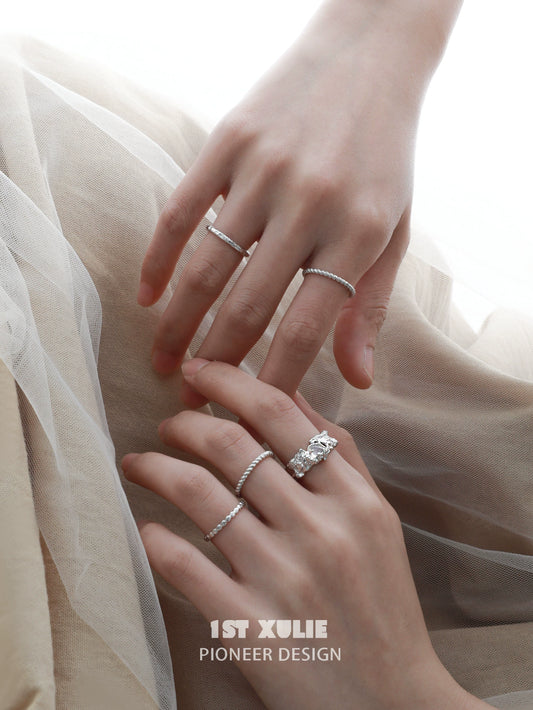 Elegant white agate ring displayed with silver stacking rings on a woman's hands