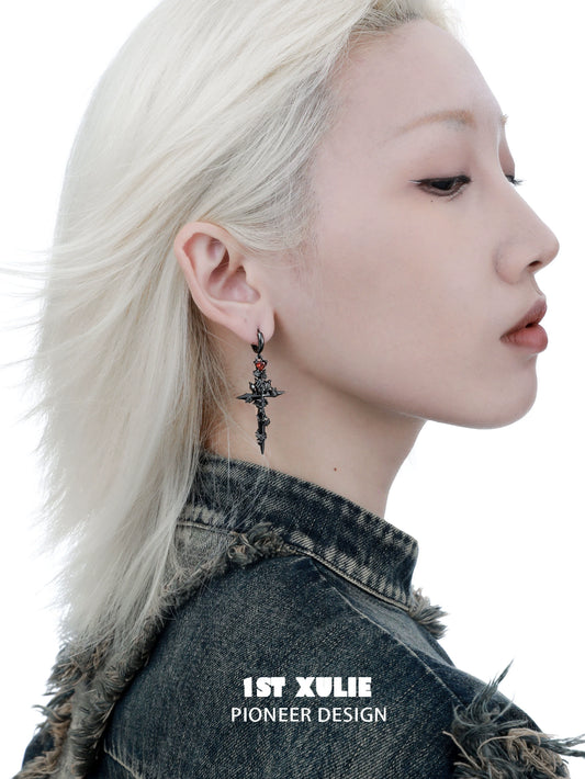 Trendy Y2K gothic cross earrings featured on a model with platinum blonde hair and edgy denim fashion