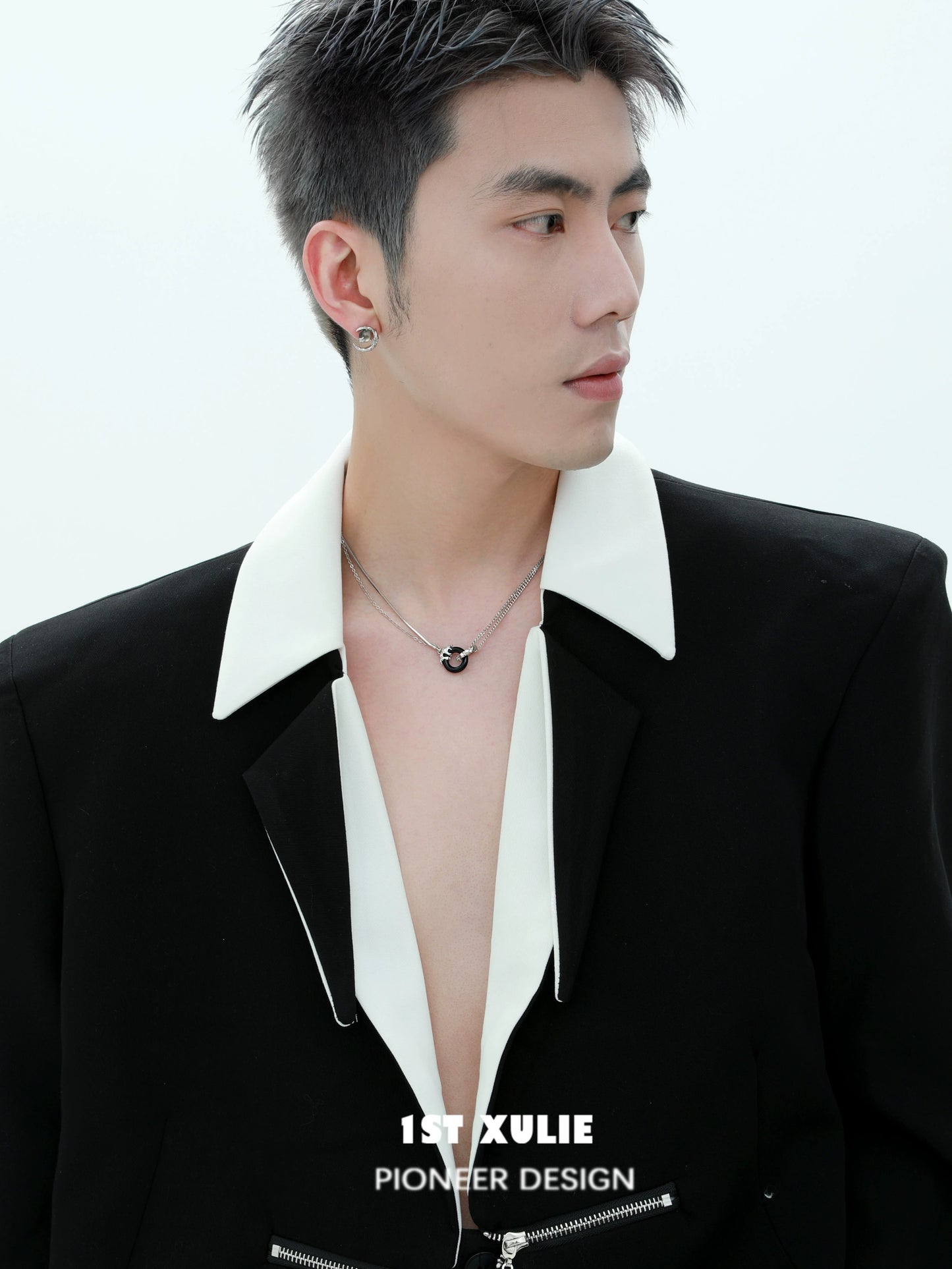 Model wearing a black and white gothic necklace styled with an oversized blazer for a modern look