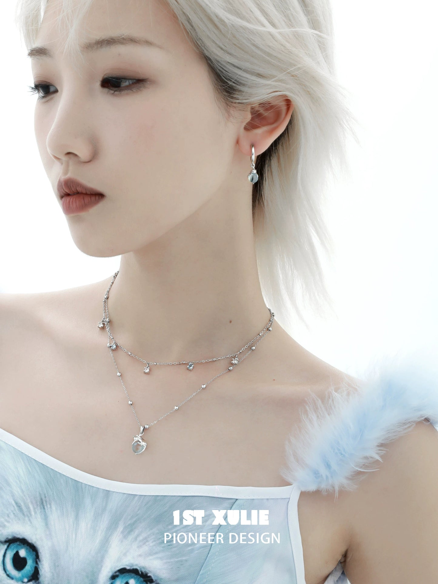 Blue kitten hoop earrings by 1STXULIE showcased on a model with layered jewelry