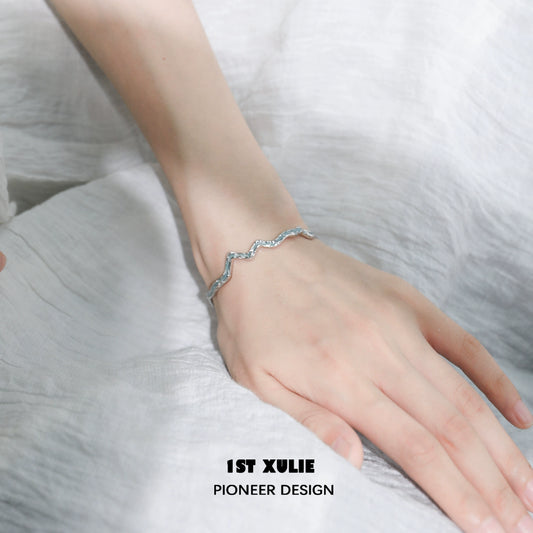 Elegant blue ocean spirit silver bracelet showcasing a wave design on a model's wrist
