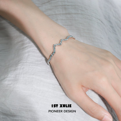 Blue ocean spirit silver bracelet displayed on a wrist showcasing its elegant wave design