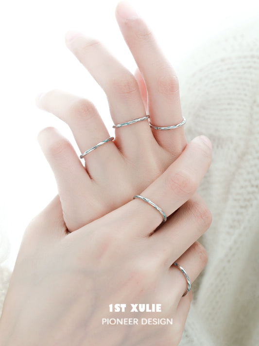 Set of delicate rings featuring a blue textured silver ring among minimalist designs