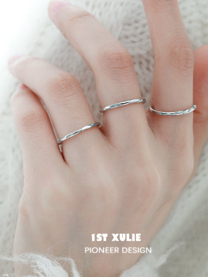 Stylish blue textured silver ring displayed on a hand with multiple rings for a trendy look