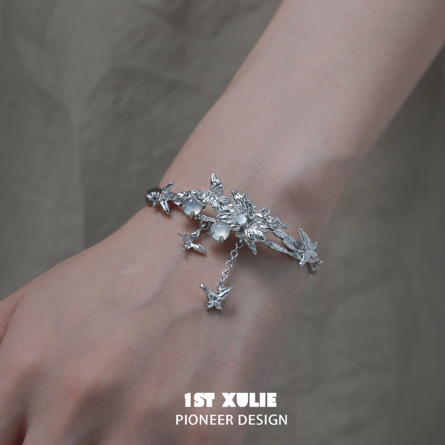 Butterfly tassel white agate bracelet with intricate floral design worn on a hand