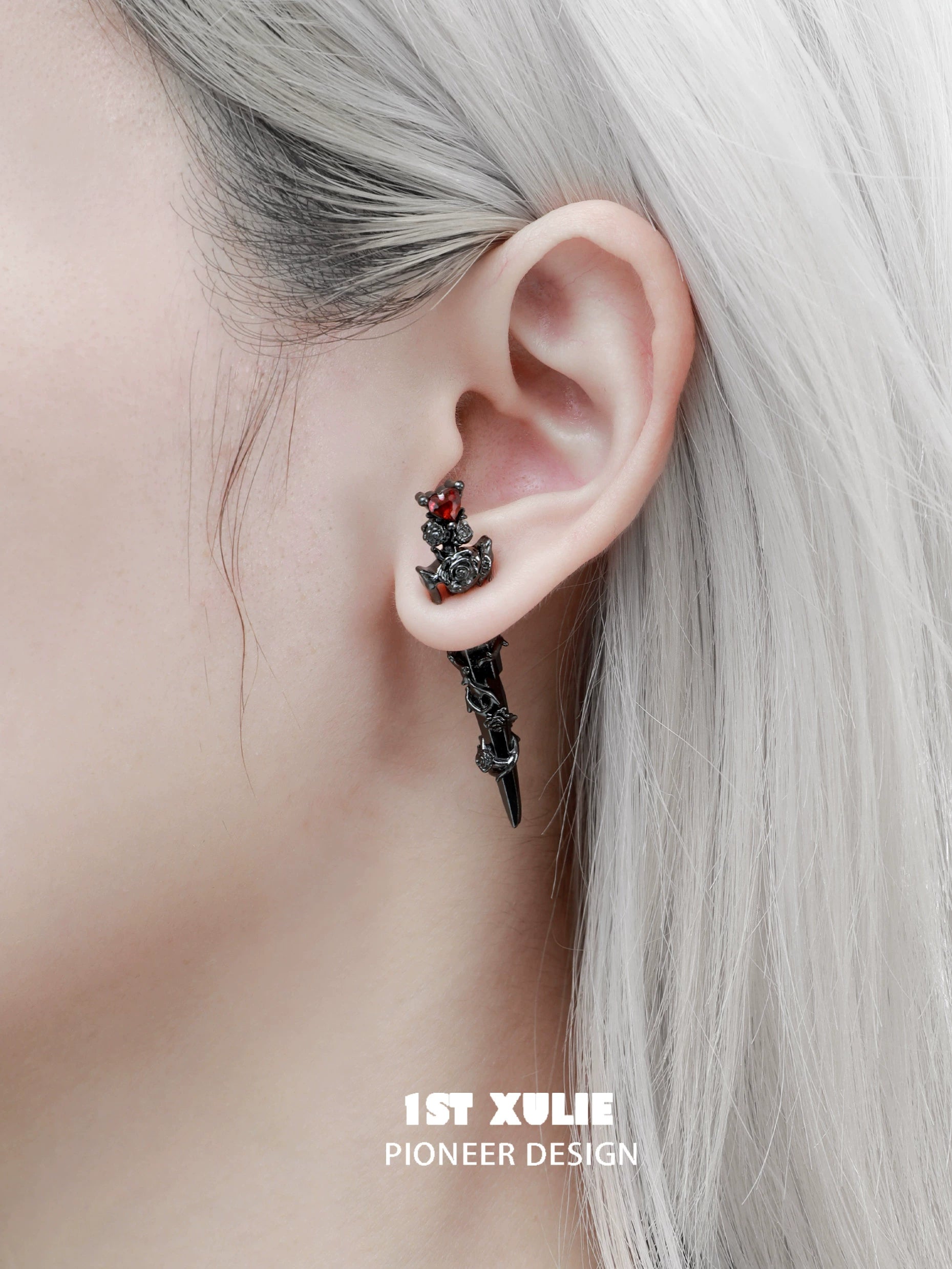 Cathedral rose piercing earrings in black with red accents showcased on a model's ear