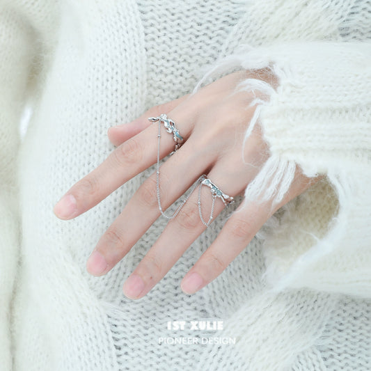 Silver chain double ring design displayed on a hand wearing a cozy sweater