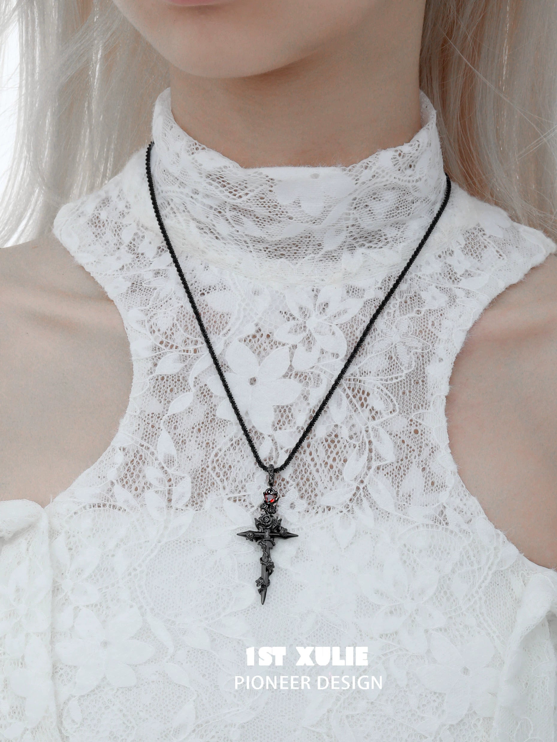 Diablo rose cross necklace in silver with intricate detailing, worn on a lace top