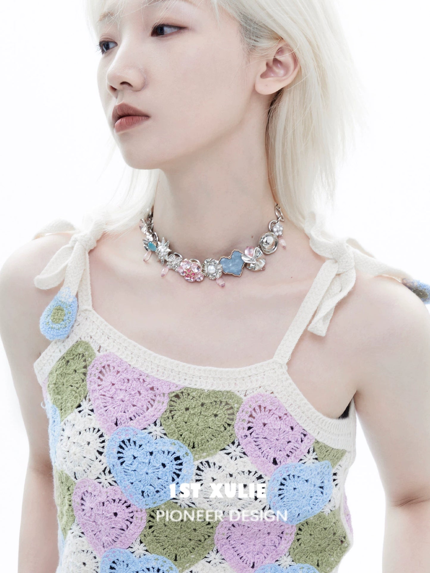 Dopamine choker necklace with colorful charms on a model wearing a crochet top