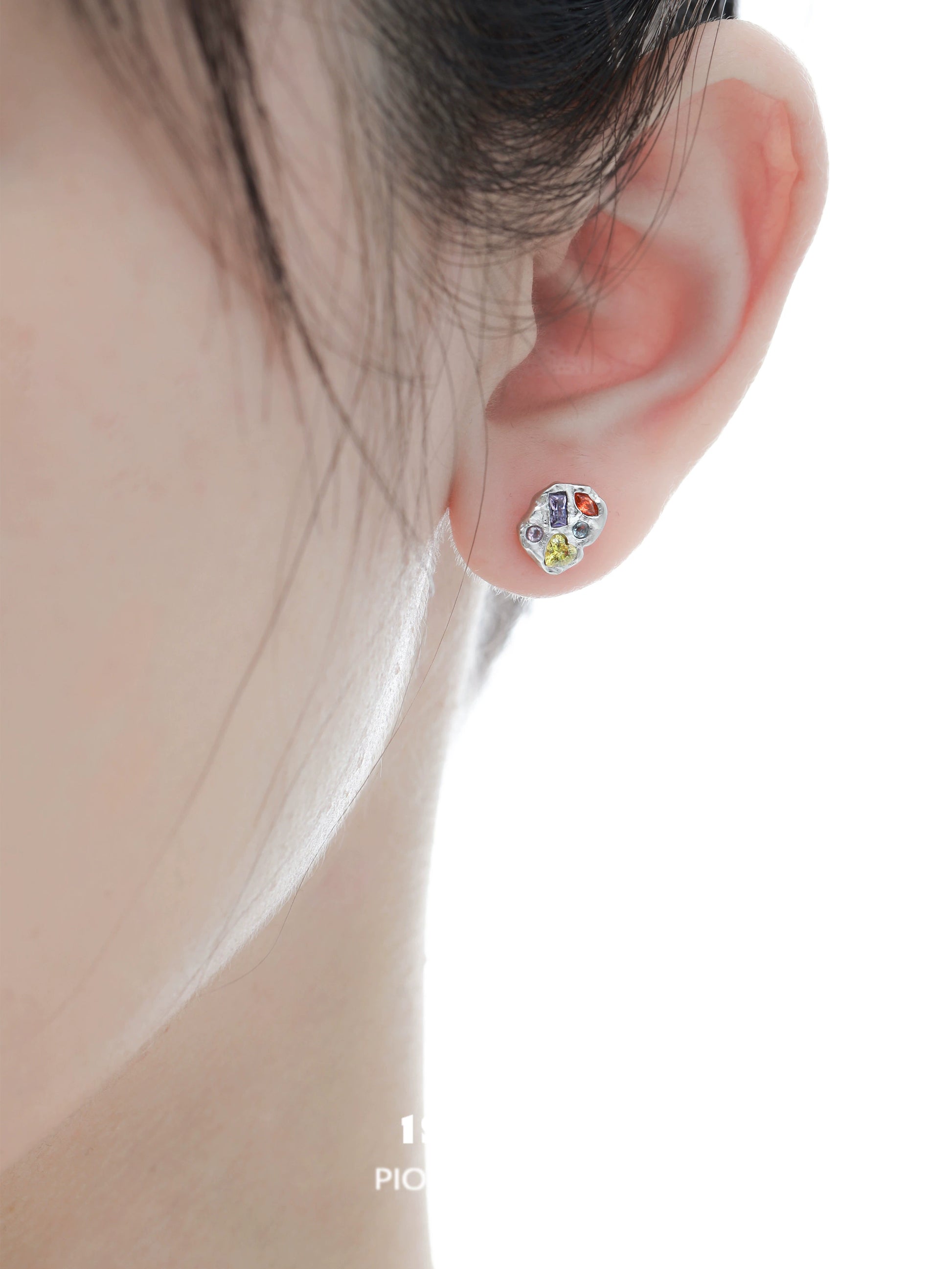 Colorful studs in a woman's ear featuring dopamine earrings for a vibrant, playful look