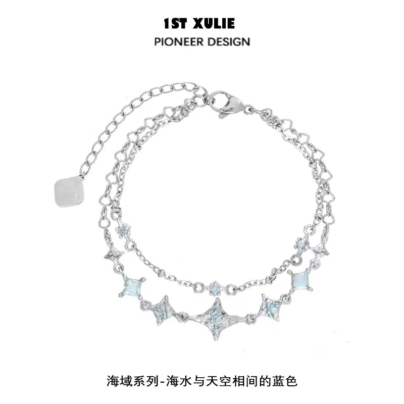 Double layer starfish silver bracelet featuring shimmering blue accents and a delicate chain design