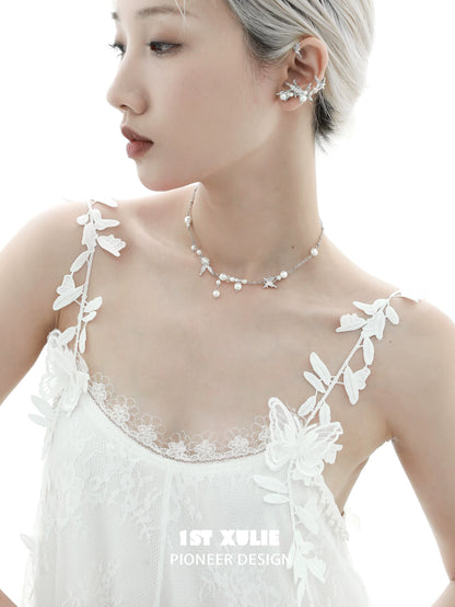 Elegant woman wearing a dream wings pearl necklace with delicate floral details and soft styling