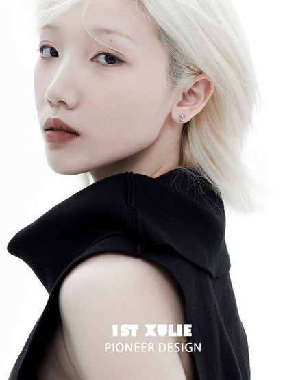 Model showcasing edgy letter silver stud earrings in a stylish black outfit