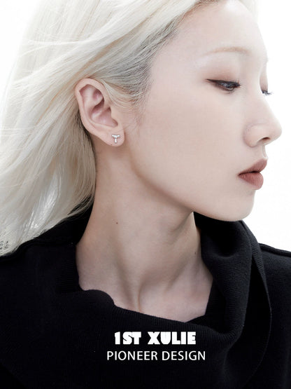 Edgy letter silver stud earrings featured on model with sleek hairstyle and minimal makeup