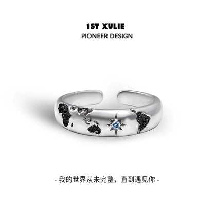 Eroded earth couple rings by 1STXULIE featuring a world map design and a blue gemstone accent