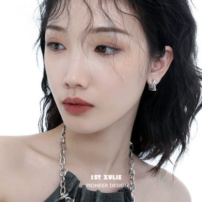 Frosted geometric earrings displayed on a model with wavy hair and natural makeup