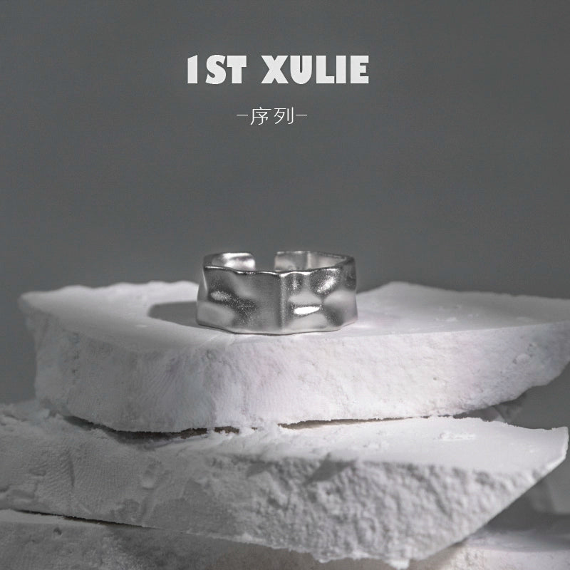 Futuristic silver ring displayed on a textured stone surface for modern fashion enthusiasts