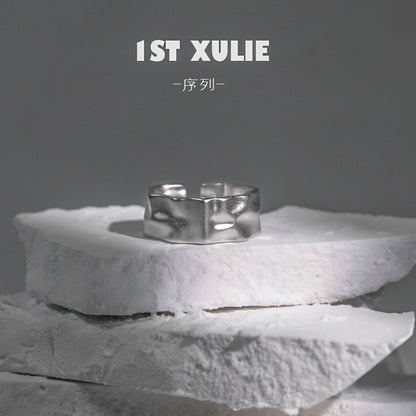 Futuristic silver ring displayed on a textured stone surface for modern fashion enthusiasts
