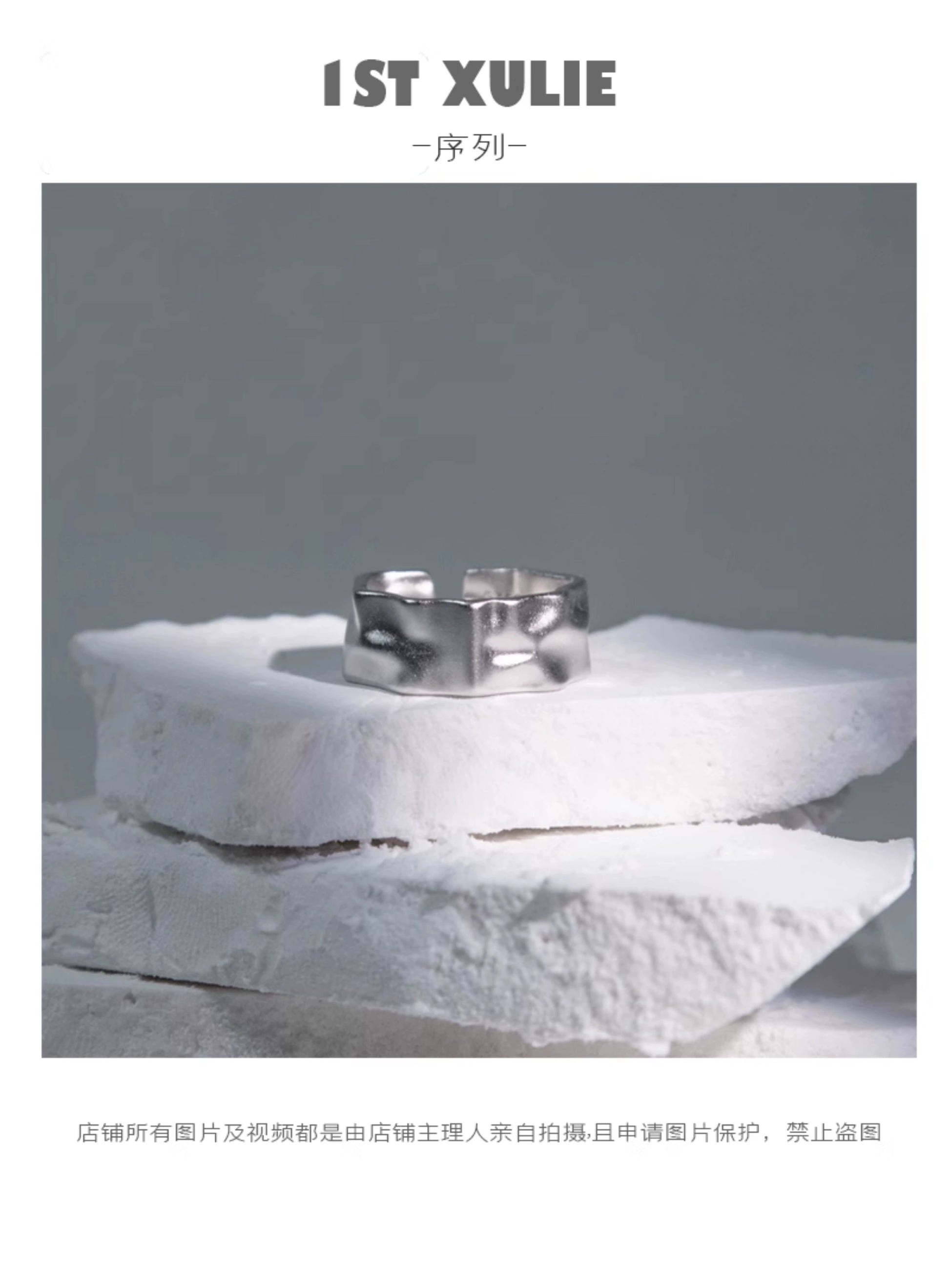 Futuristic silver ring displayed on textured white stones for a modern jewelry collection