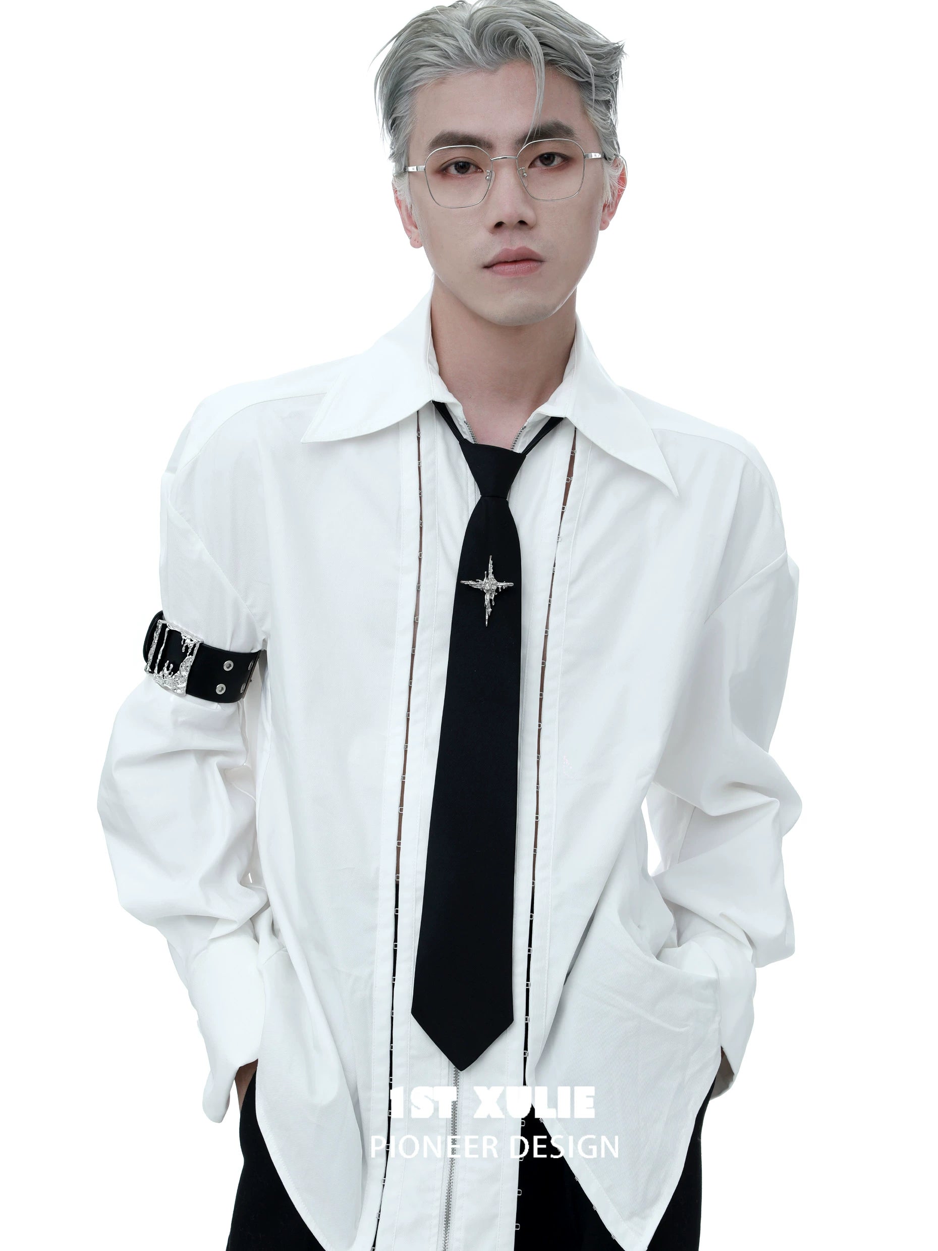 Stylish model wearing a gothic liquid metal arm bracelet with a white oversized shirt and black tie