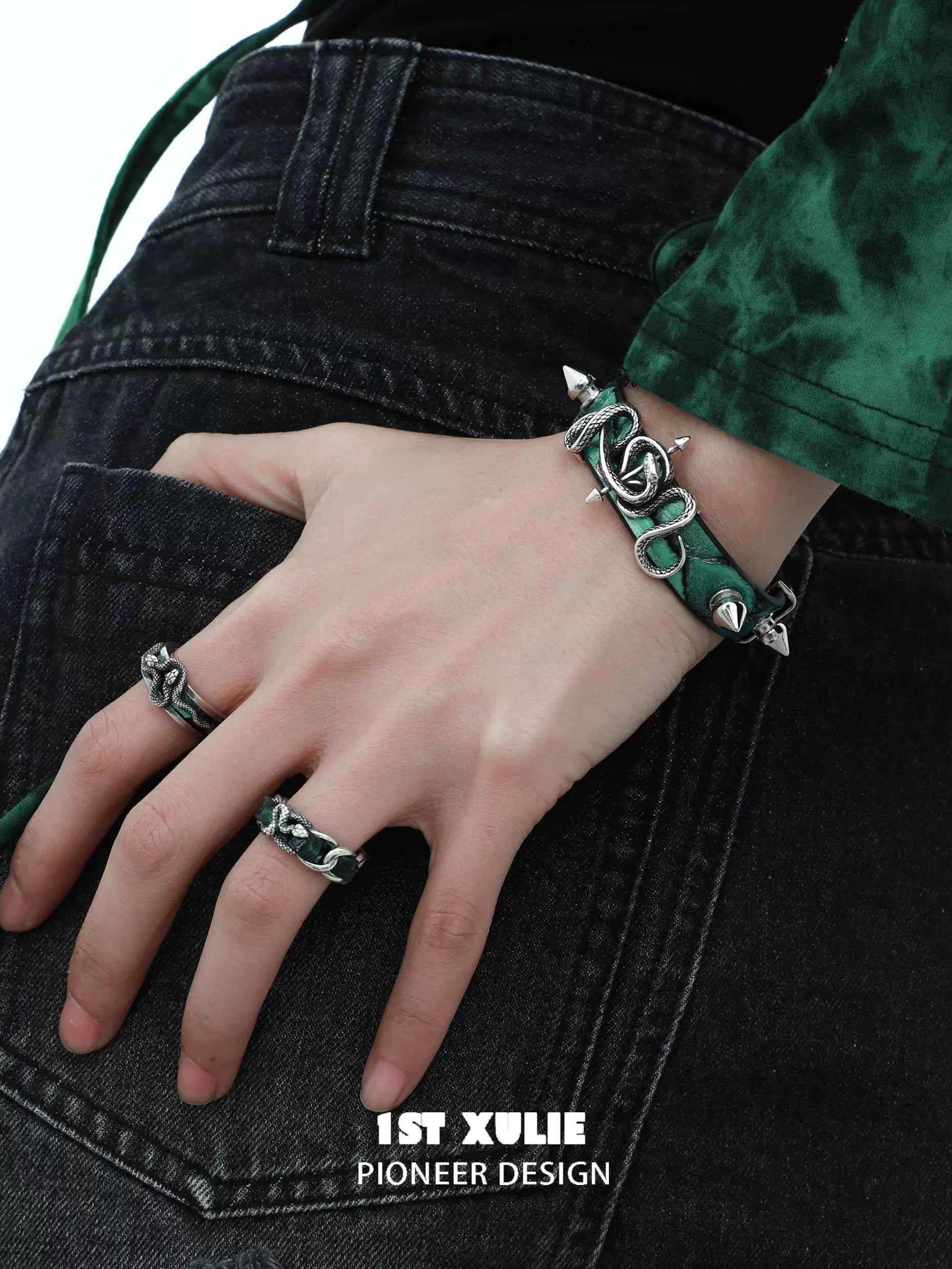 Gothic snake bracelet with spikes and chain design worn on a hand over dark jeans