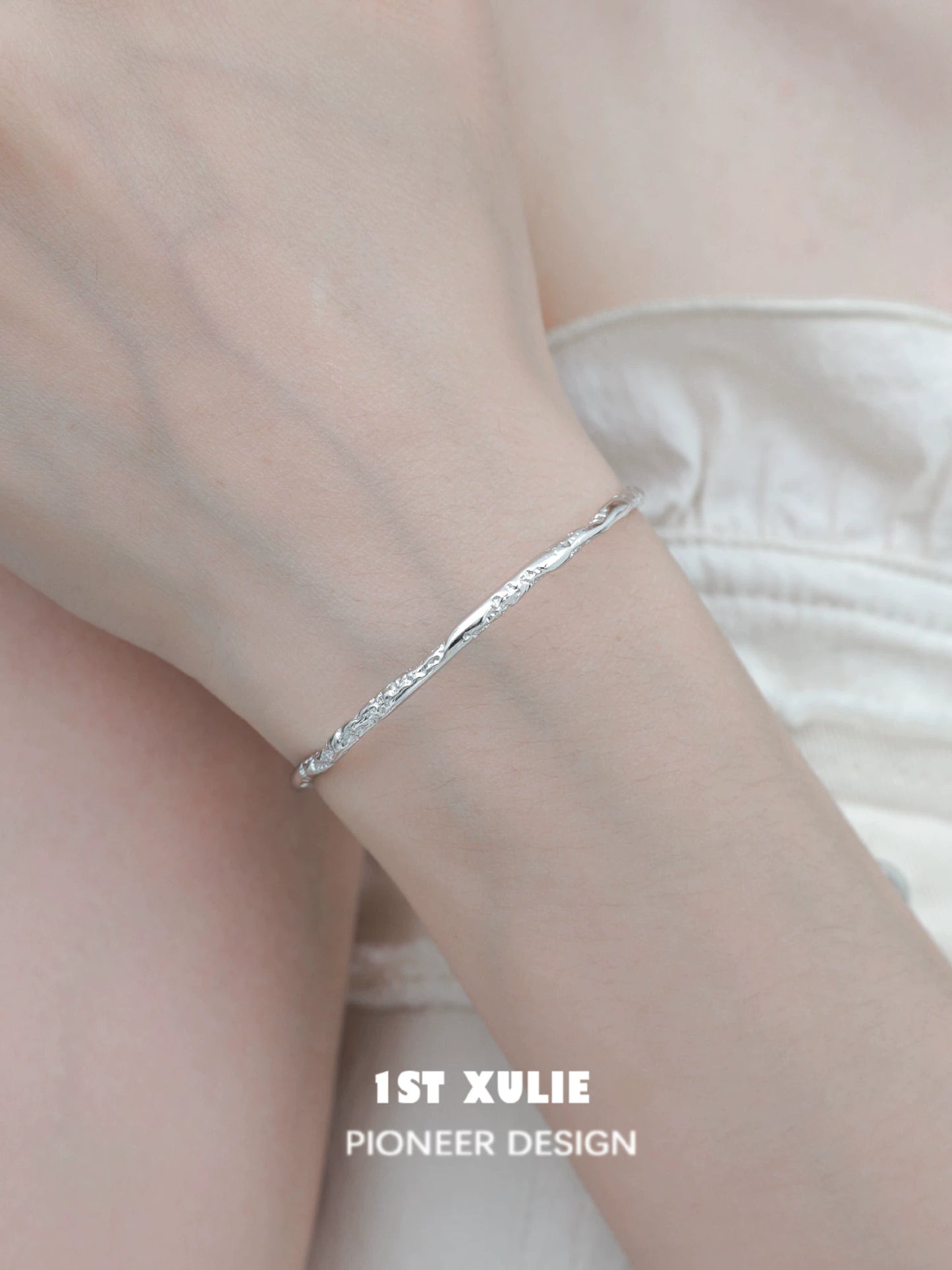 Elegant minimalist silver bracelet showcased on a model's wrist, perfect for everyday wear