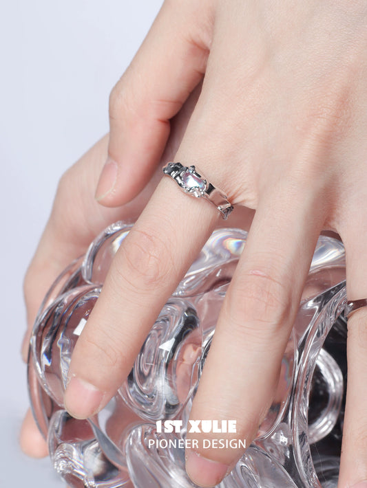Elegant moonstone silver ring with a unique design, showcased on a hand holding a glass vase