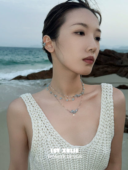 Elegant model wearing mystic mermaid tail earrings showcasing a beachy, ocean-inspired look