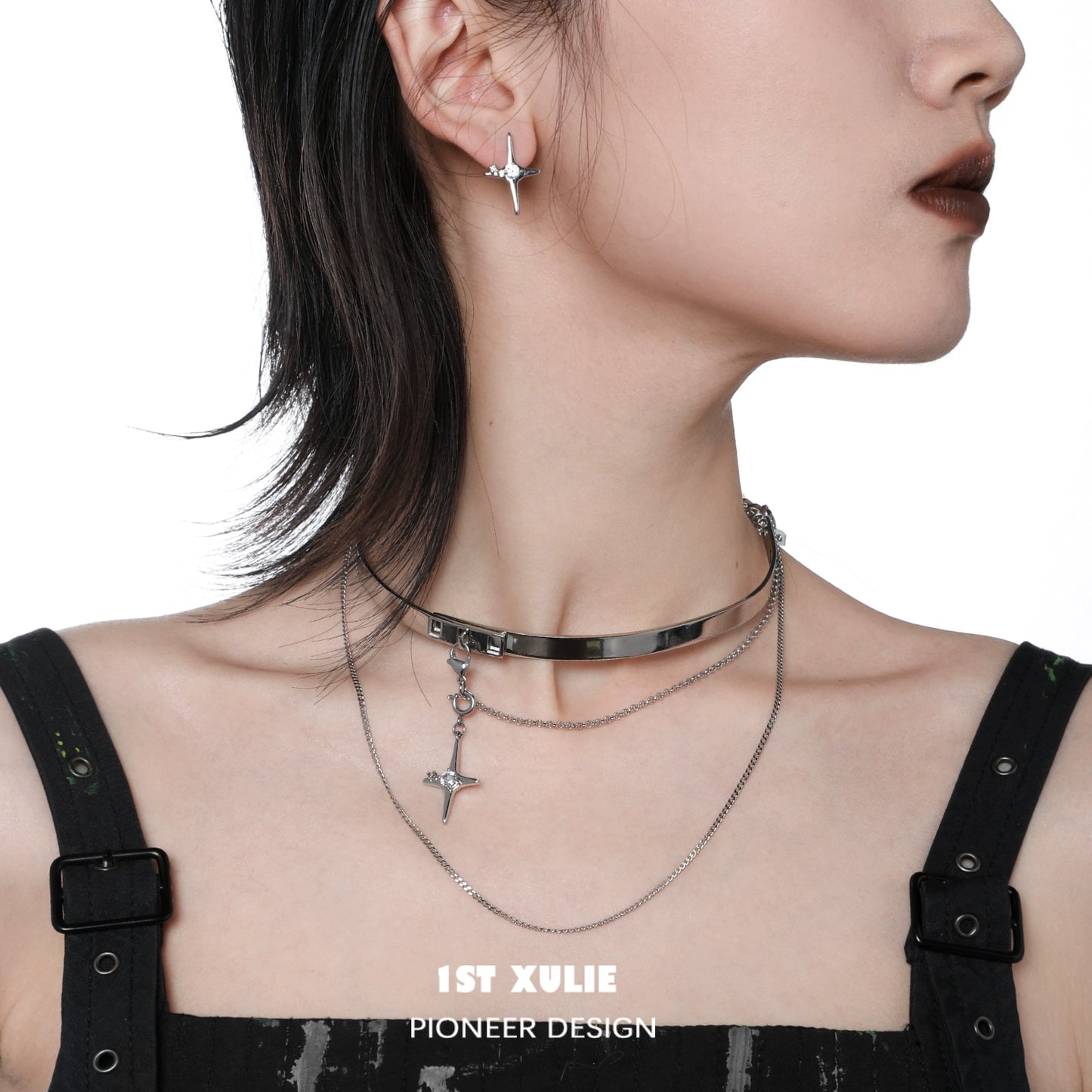 Mystic star necklace layered with silver chains, worn stylishly with black outfit and earrings
