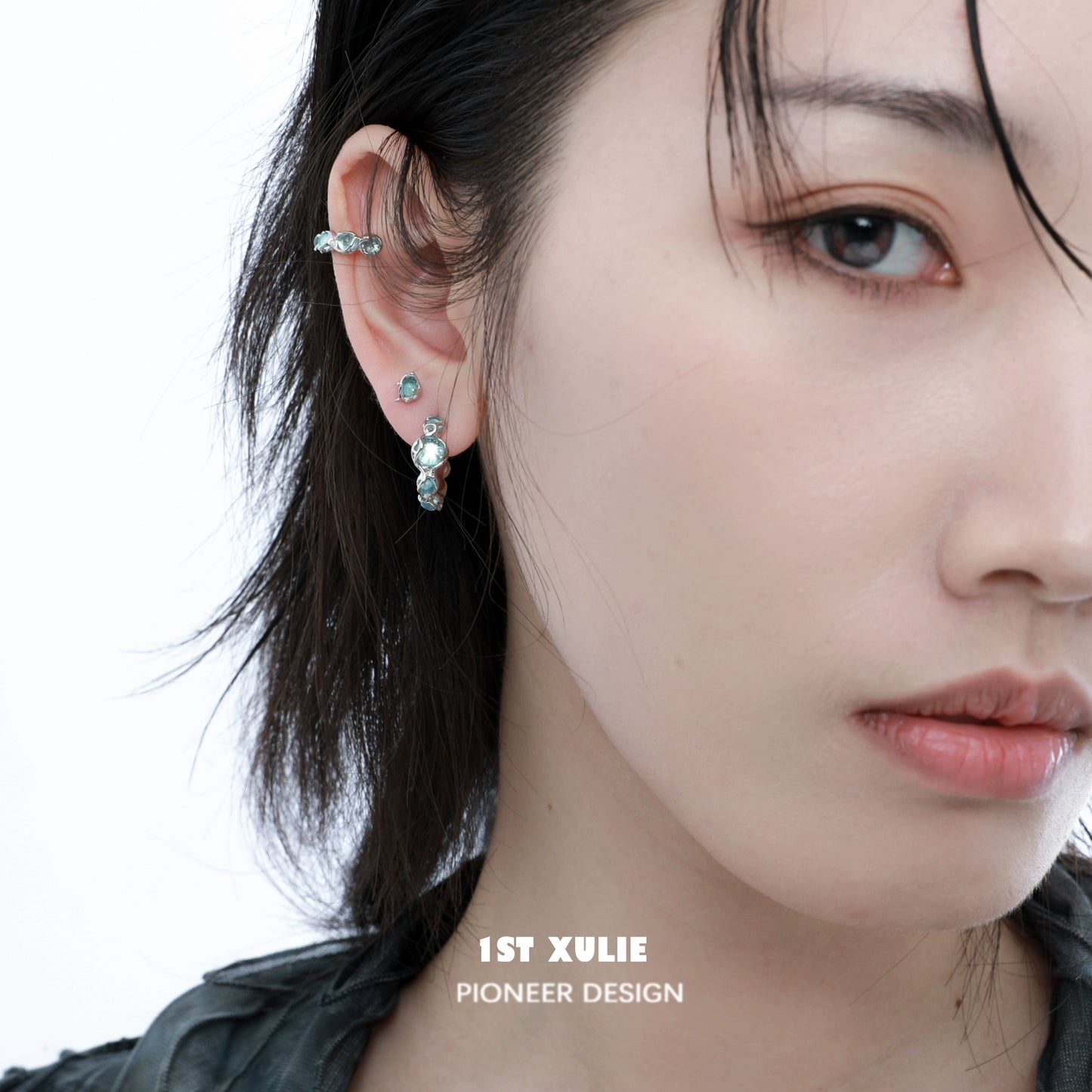 Elegant ocean blue stud earrings set on a model's ear, complementing her style with a modern touch