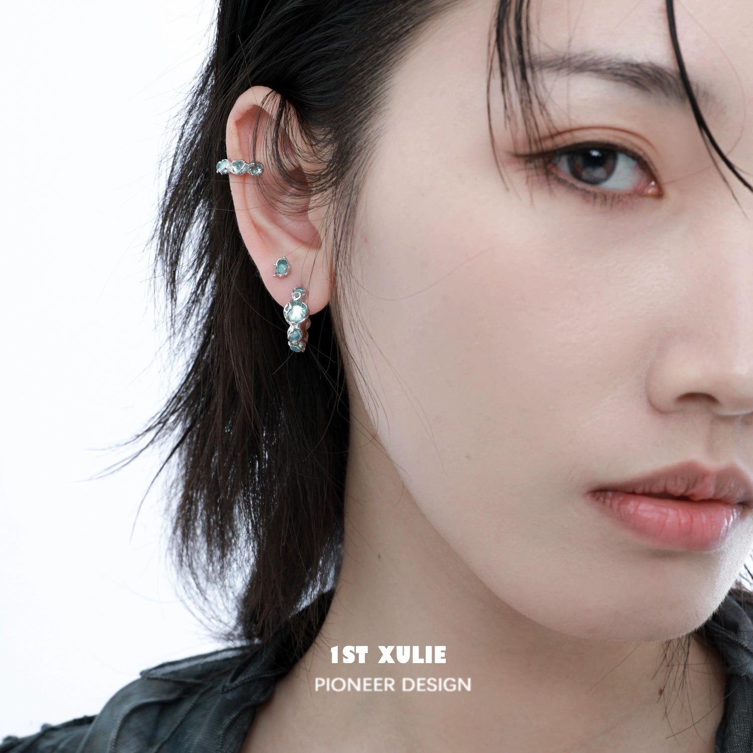 Elegant ocean blue stud earrings set on a model's ear, complementing her style with a modern touch