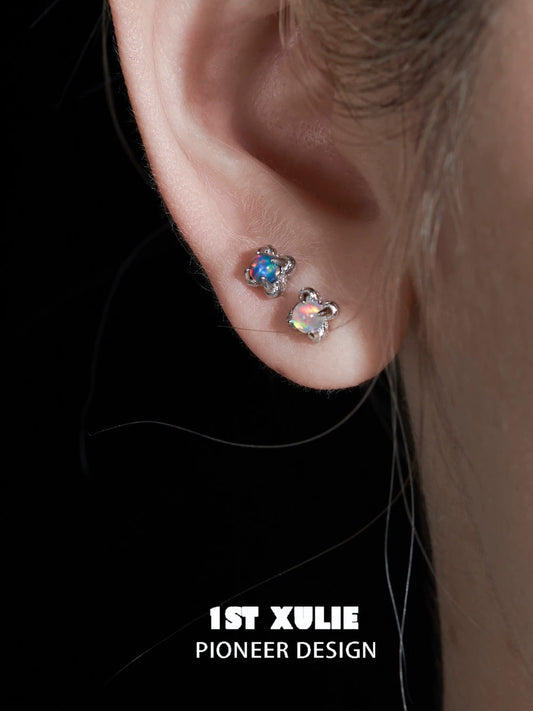 Opal stud earrings elegantly displayed on a model's ear for a sparkling look