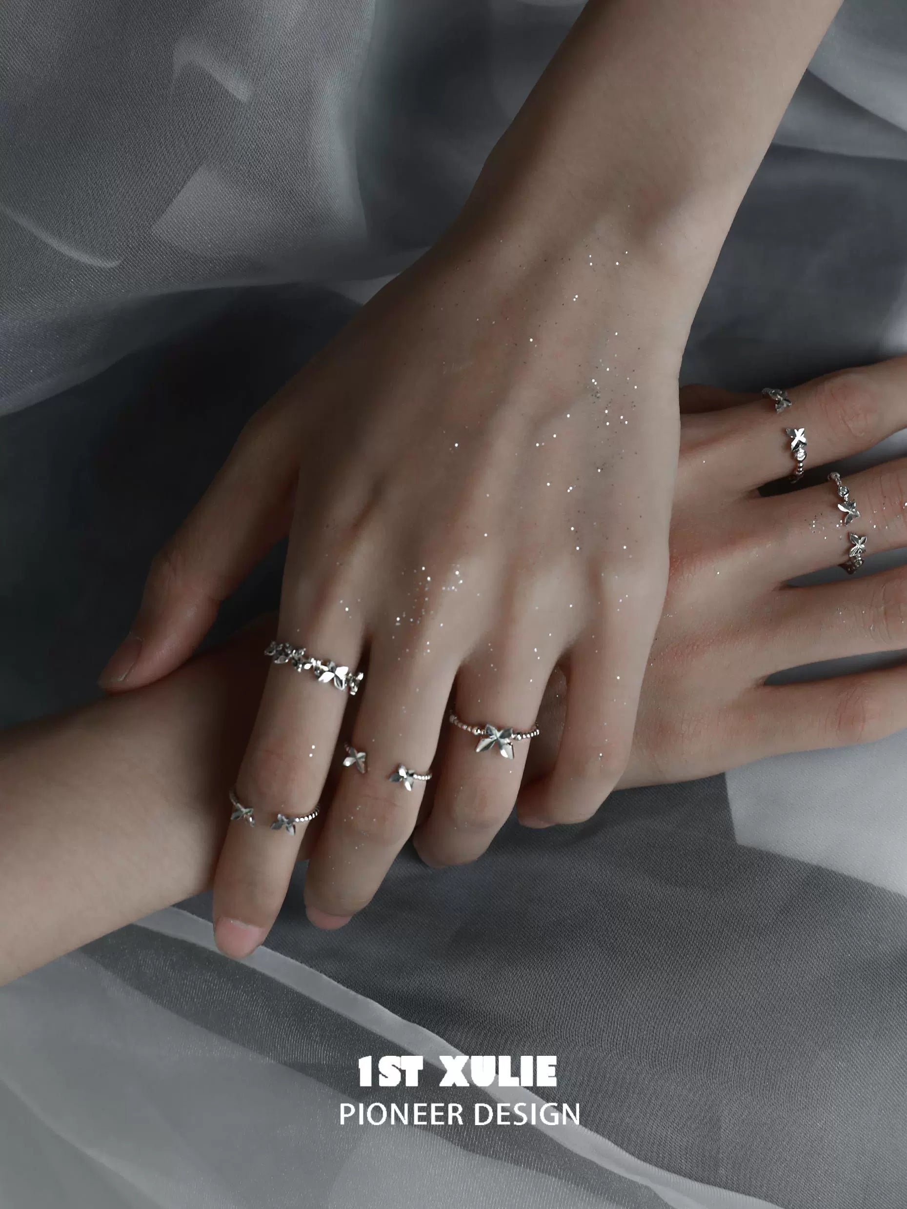 Stylish punk butterfly silver ring showcased among multiple rings on stylish hands