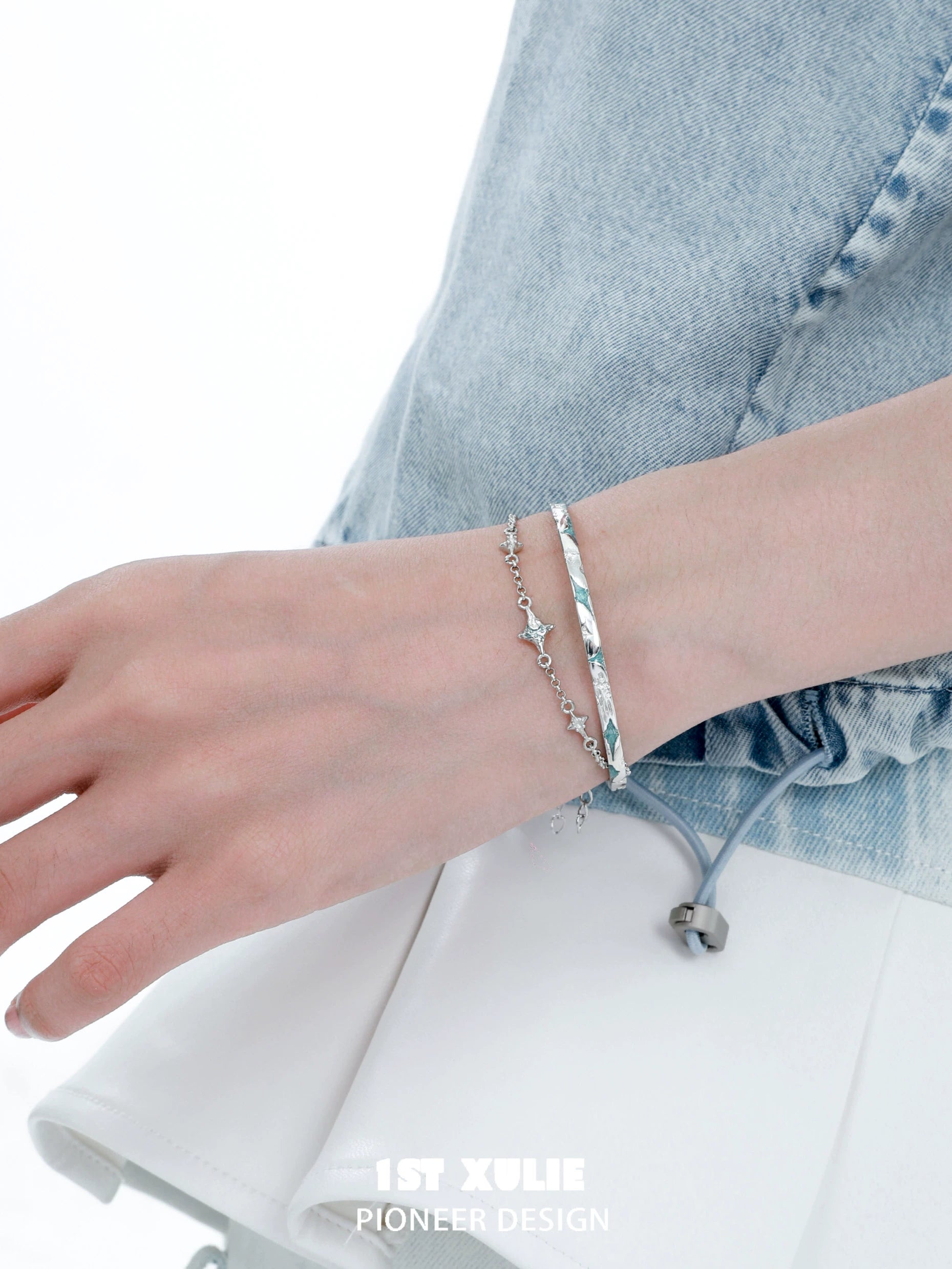 Elegant silver starlight bracelet on a hand, paired with a chic outfit for a stylish look