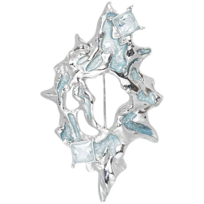 Unique silver statement brooch with blue accents and geometric designs, perfect for adding flair to outfits