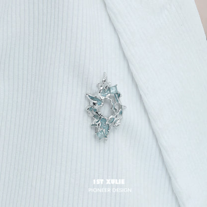 Elegant silver statement brooch featuring sparkling blue accents for stylish decor