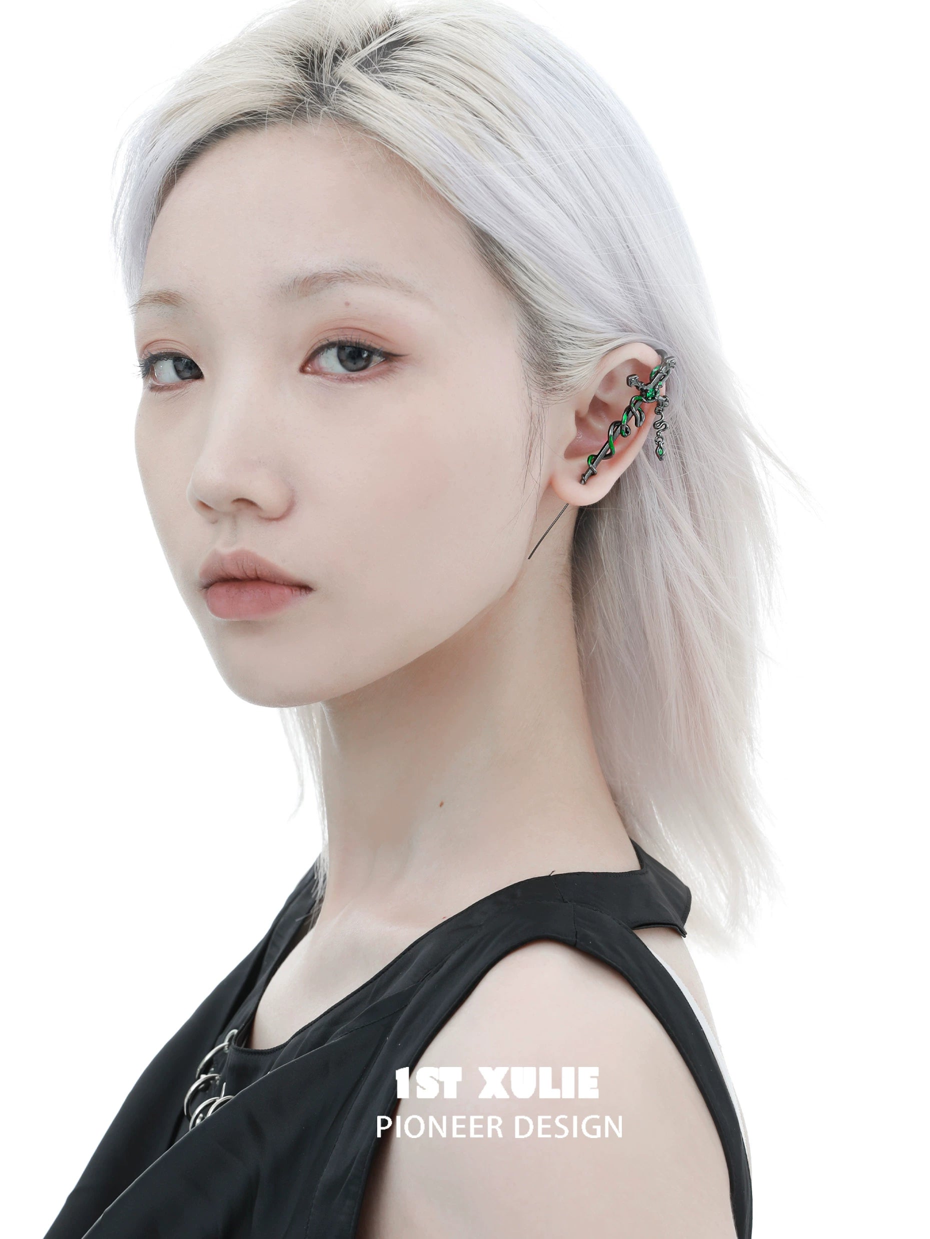 Unique Slytherin cross piercing earring in silver and green worn by a model with light hair