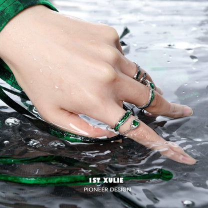 Slytherin inspired green snake ring on a hand submerged in water with a stylish green outfit