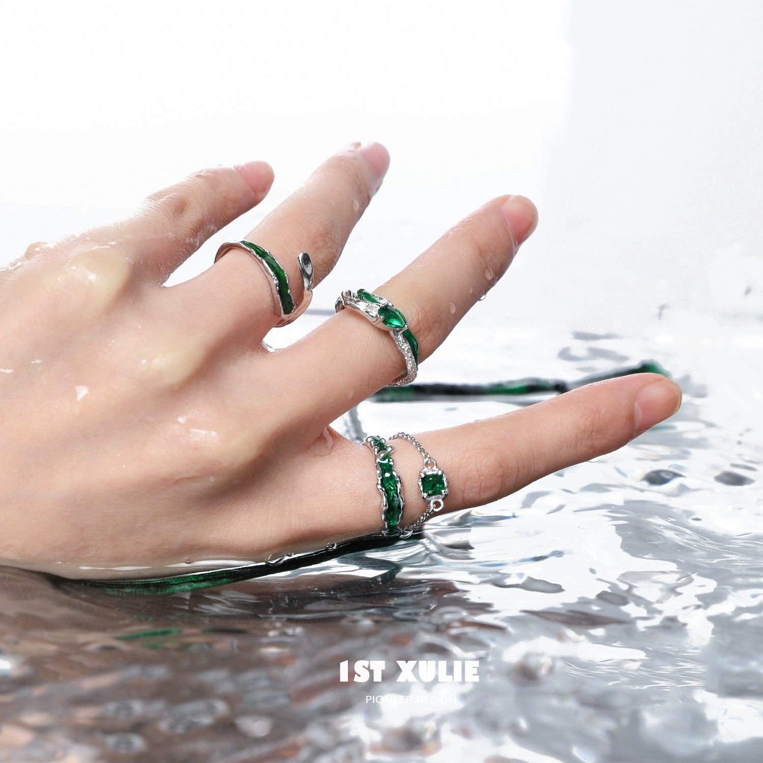 Slytherin inspired green snake ring set featuring intricate designs on a hand above water