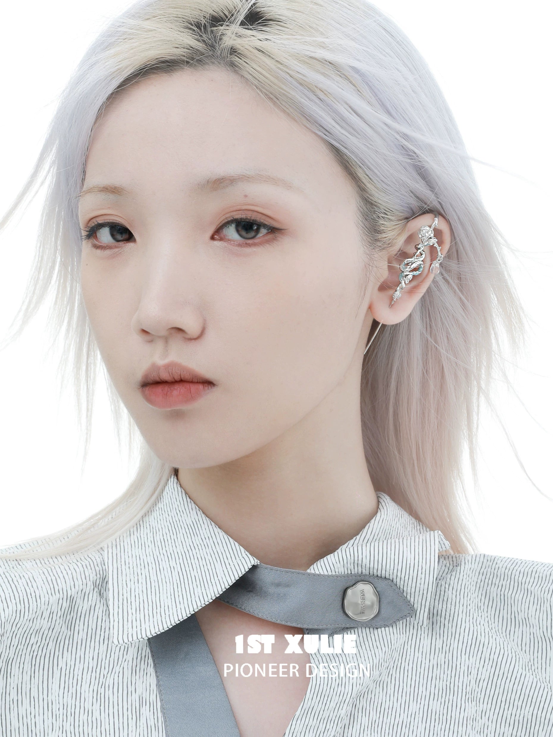 Stylish snake ear piercing jewelry displayed on a model with silver hair and a chic outfit